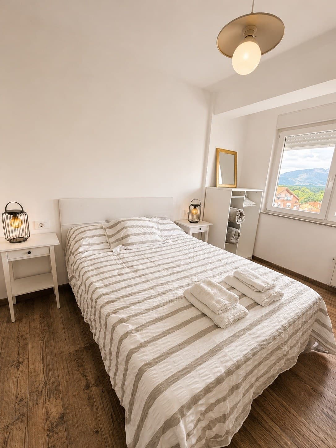 Dormitorio principal con cama de matrimonio, mesitas de noche y vistas hacia la montaña