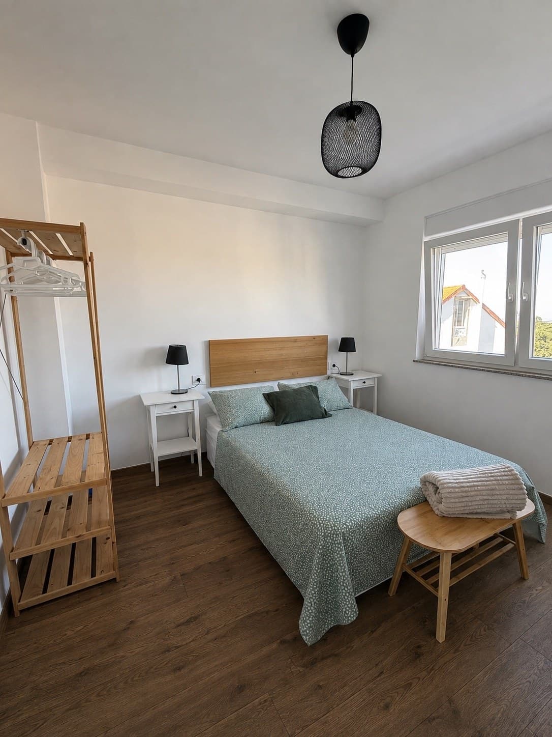 Dormitorio acogedor con cama de matrimonio, cabecero de madera y luz natural
